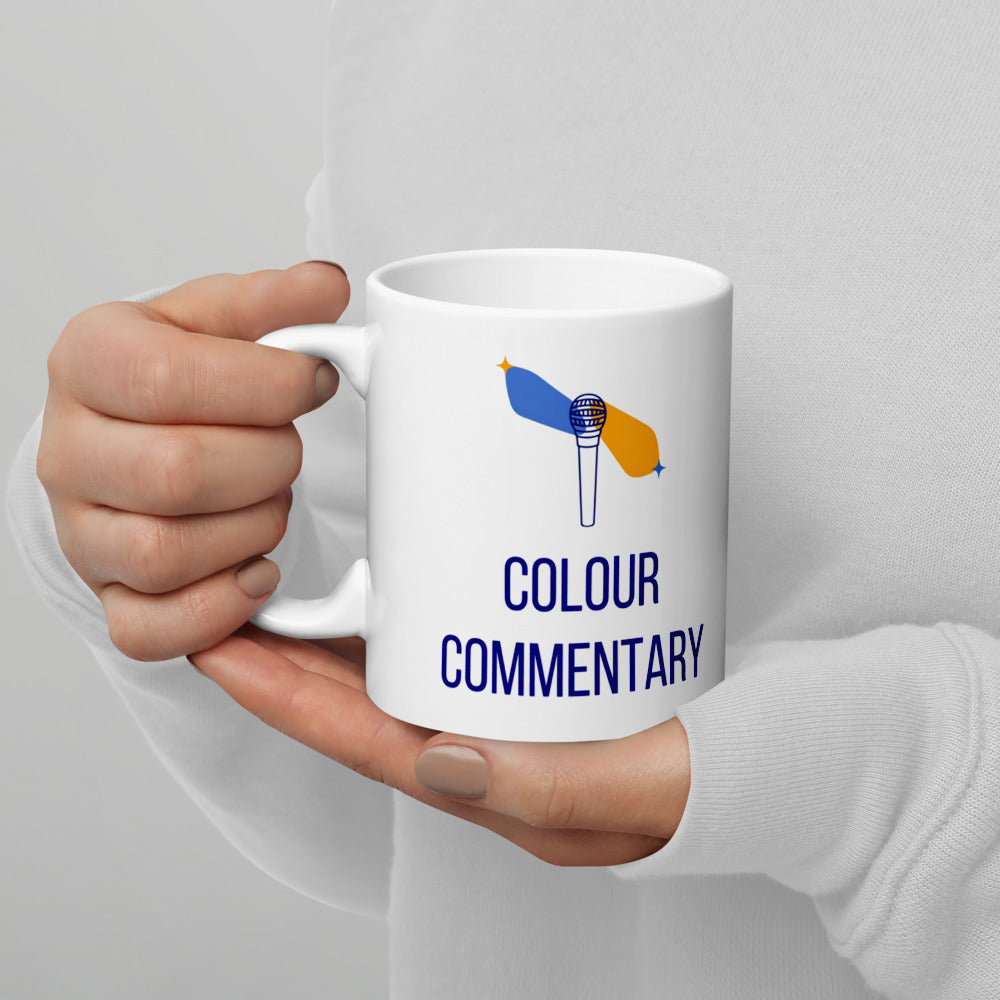 Left hand holding the 11 oz Colour Commentary mug, showing the design printed on the handle-left side