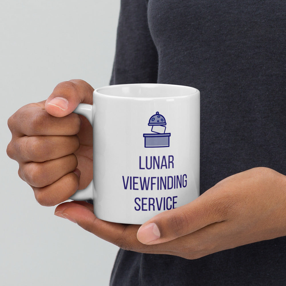 Hands holding the 11 oz Lunar Viewfinding Service mug by the handle against a dark sweater