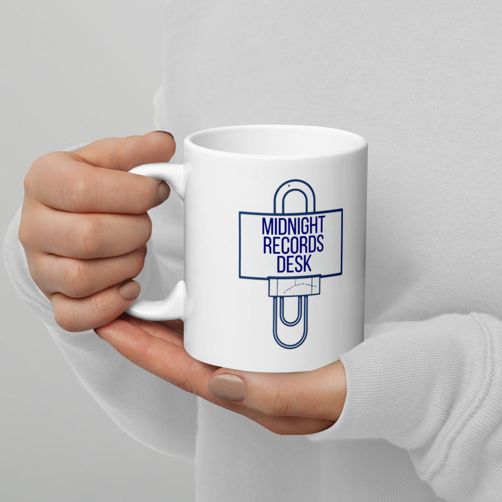 Holding the Midnight Records Desk astronomy mug by the handle, paper clip and sign design facing out