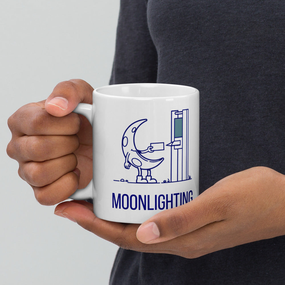 Hand holding the moonlighting mug by its handle, the crescent moon punching in and the MOONLIGHTING lettering facing out