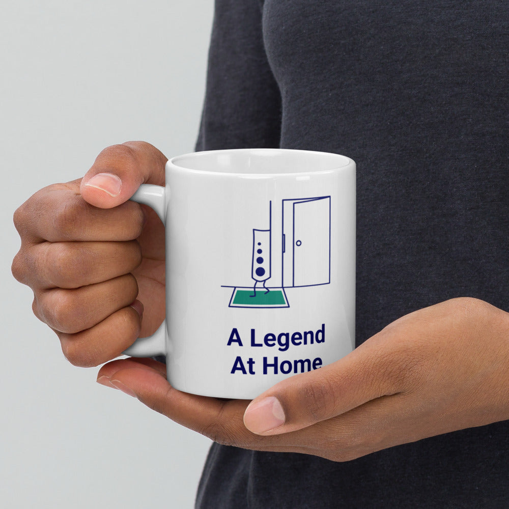 Hands holding the star atlas mug by its handle, the star-dot legend and A Legend At Home lettering facing out