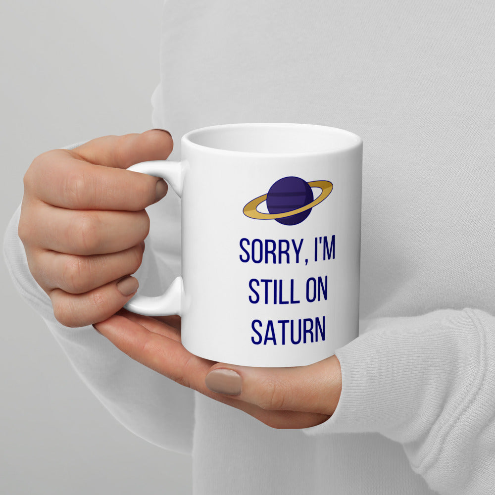 Left hand holding the 11 oz Sorry, I'm Still on Saturn mug, showing the design printed on the handle-left side