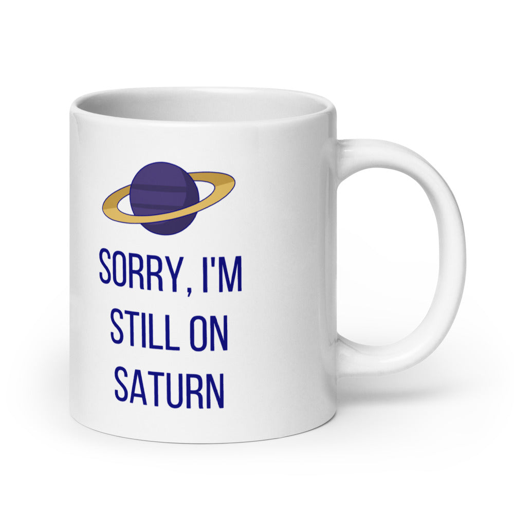20 oz Saturn mug, handle on the right, the widest size with the gold-ringed planet and Sorry, I'm Still on Saturn lettering